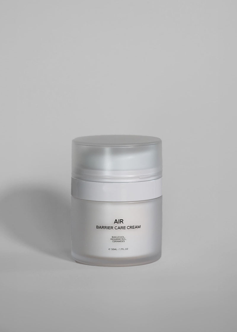 A frosted glass jar of AIR Barrier Care Cream with a translucent cap, set against a solid light gray background.